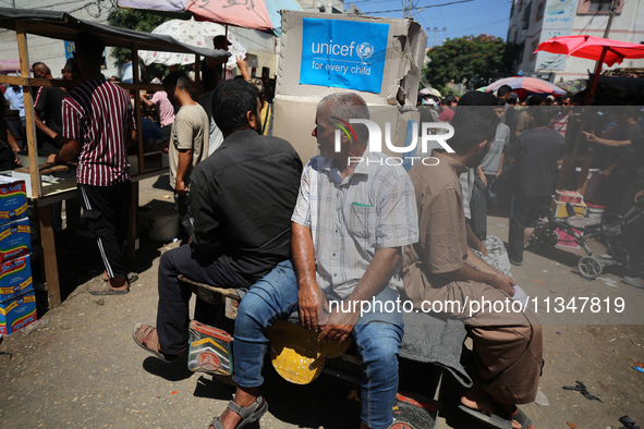 People are walking in a market in Deir al-Balah in the central Gaza Strip, on June 21, 2024, as the conflict in the Palestinian territory be...