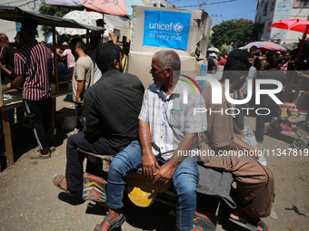 People are walking in a market in Deir al-Balah in the central Gaza Strip, on June 21, 2024, as the conflict in the Palestinian territory be...