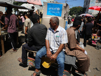 People are walking in a market in Deir al-Balah in the central Gaza Strip, on June 21, 2024, as the conflict in the Palestinian territory be...