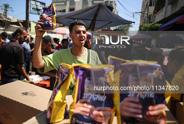 A Palestinian is displaying his wares in a market in Deir al-Balah in the central Gaza Strip, on June 21, 2024, as the conflict is continuin...