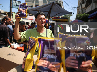 A Palestinian is displaying his wares in a market in Deir al-Balah in the central Gaza Strip, on June 21, 2024, as the conflict is continuin...