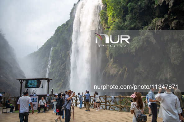 Tourists are viewing a waterfall at the Maling River Canyon scenic spot in Xingyi, China, on June 21, 2024. 