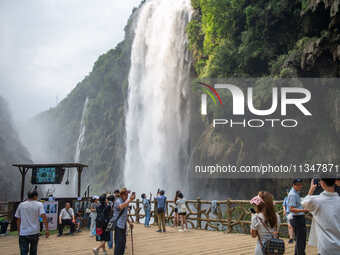 Tourists are viewing a waterfall at the Maling River Canyon scenic spot in Xingyi, China, on June 21, 2024. (