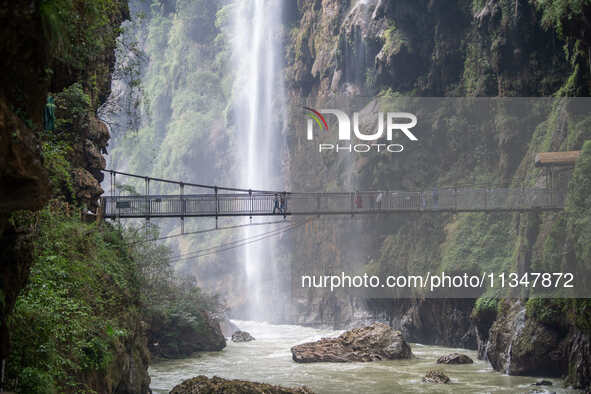 Tourists are viewing a waterfall at the Maling River Canyon scenic spot in Xingyi, China, on June 21, 2024. 