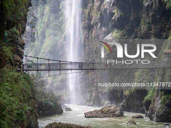 Tourists are viewing a waterfall at the Maling River Canyon scenic spot in Xingyi, China, on June 21, 2024. (