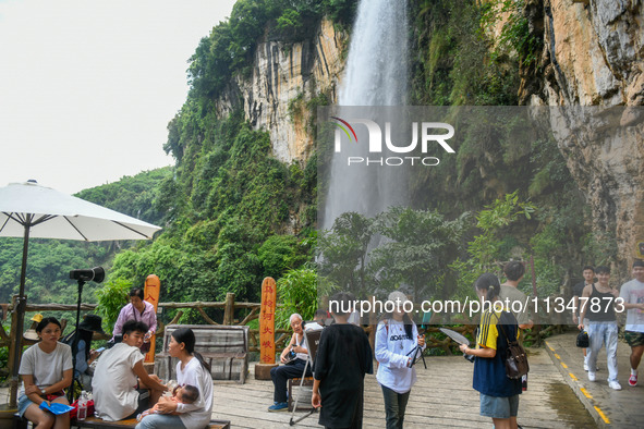 Tourists are viewing a waterfall at the Maling River Canyon scenic spot in Xingyi, China, on June 21, 2024. 