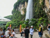 Tourists are viewing a waterfall at the Maling River Canyon scenic spot in Xingyi, China, on June 21, 2024. (