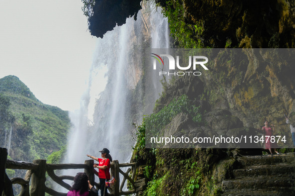 Tourists are viewing a waterfall at the Maling River Canyon scenic spot in Xingyi, China, on June 21, 2024. 