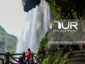 Tourists are viewing a waterfall at the Maling River Canyon scenic spot in Xingyi, China, on June 21, 2024. (