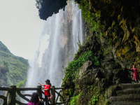 Tourists are viewing a waterfall at the Maling River Canyon scenic spot in Xingyi, China, on June 21, 2024. (