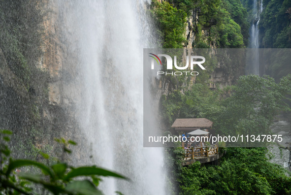 Tourists are viewing a waterfall at the Maling River Canyon scenic spot in Xingyi, China, on June 21, 2024. 