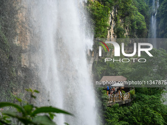 Tourists are viewing a waterfall at the Maling River Canyon scenic spot in Xingyi, China, on June 21, 2024. (