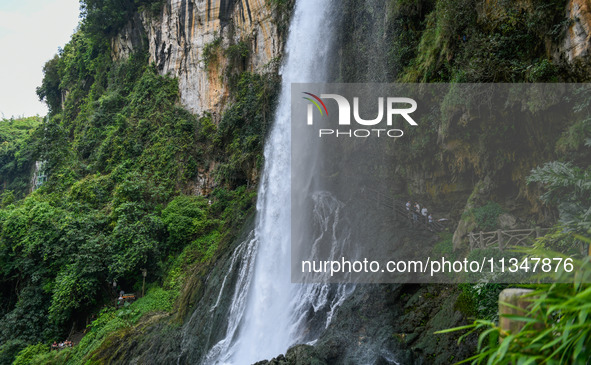 Tourists are viewing a waterfall at the Maling River Canyon scenic spot in Xingyi, China, on June 21, 2024. 