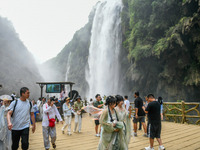 Tourists are viewing a waterfall at the Maling River Canyon scenic spot in Xingyi, China, on June 21, 2024. (