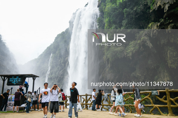 Tourists are viewing a waterfall at the Maling River Canyon scenic spot in Xingyi, China, on June 21, 2024. 