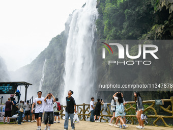 Tourists are viewing a waterfall at the Maling River Canyon scenic spot in Xingyi, China, on June 21, 2024. (