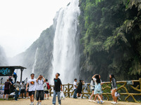 Tourists are viewing a waterfall at the Maling River Canyon scenic spot in Xingyi, China, on June 21, 2024. (