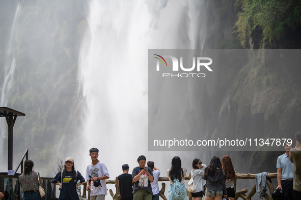 Tourists are viewing a waterfall at the Maling River Canyon scenic spot in Xingyi, China, on June 21, 2024. 