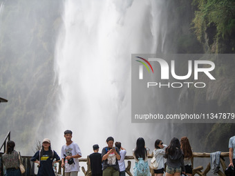 Tourists are viewing a waterfall at the Maling River Canyon scenic spot in Xingyi, China, on June 21, 2024. (