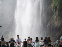 Tourists are viewing a waterfall at the Maling River Canyon scenic spot in Xingyi, China, on June 21, 2024. (