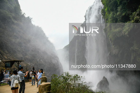 Tourists are viewing a waterfall at the Maling River Canyon scenic spot in Xingyi, China, on June 21, 2024. 