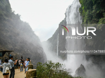 Tourists are viewing a waterfall at the Maling River Canyon scenic spot in Xingyi, China, on June 21, 2024. (