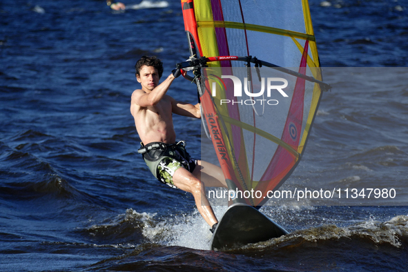 A man is practicing windsurfing on the Kremenchuk Reservoir in Cherkasy, Ukraine, on June 20, 2024. NO USE RUSSIA. NO USE BELARUS. 