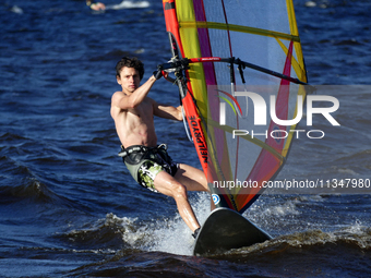 A man is practicing windsurfing on the Kremenchuk Reservoir in Cherkasy, Ukraine, on June 20, 2024. NO USE RUSSIA. NO USE BELARUS. (