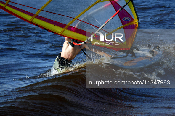 A windsurfer is struggling with the board and sail on the Kremenchuk Reservoir in Cherkasy, Ukraine, on June 20, 2024. NO USE RUSSIA. NO USE...