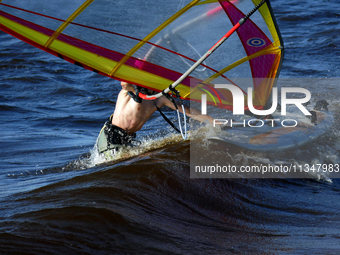 A windsurfer is struggling with the board and sail on the Kremenchuk Reservoir in Cherkasy, Ukraine, on June 20, 2024. NO USE RUSSIA. NO USE...