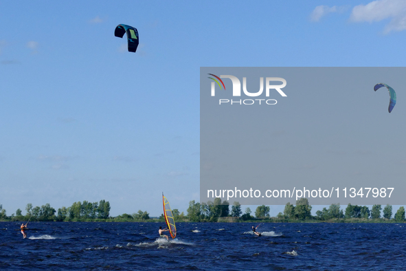 People are practicing kiteboarding and windsurfing on the Kremenchuk Reservoir in Cherkasy, Ukraine, on June 20, 2024. NO USE RUSSIA. NO USE...