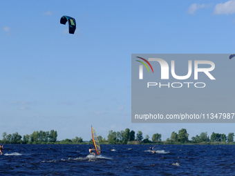 People are practicing kiteboarding and windsurfing on the Kremenchuk Reservoir in Cherkasy, Ukraine, on June 20, 2024. NO USE RUSSIA. NO USE...