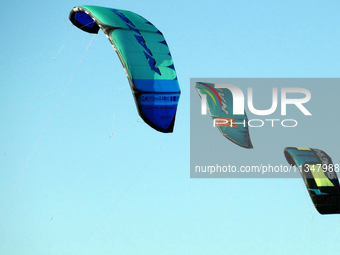 Three power kites are flying in the sky in Cherkasy, Ukraine, on June 20, 2024. (