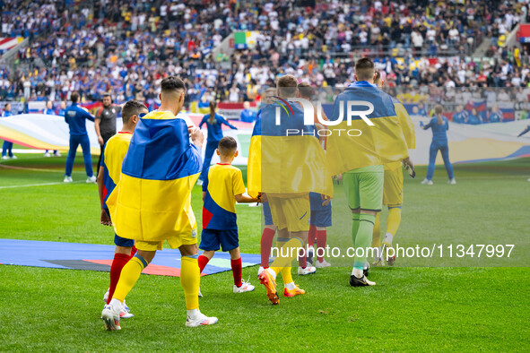 The players of Ukraine are walking onto the pitch  during the UEFA EURO 2024 group stage match between Slovakia and Ukraine at Düsseldorf Ar...