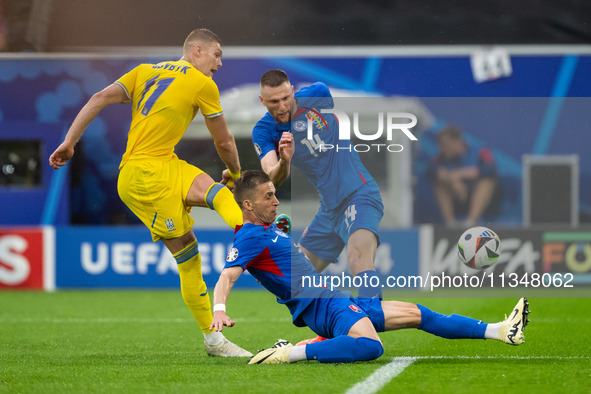 Artem Dovbyk of Ukraine is missing a chance to score against Peter Pekarik and Milan Skriniar of Slovakia  during the UEFA EURO 2024 group s...