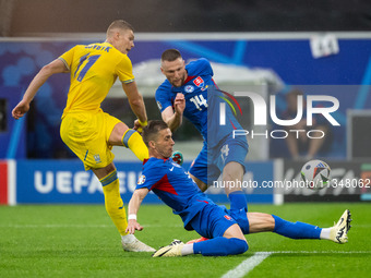 Artem Dovbyk of Ukraine is missing a chance to score against Peter Pekarik and Milan Skriniar of Slovakia  during the UEFA EURO 2024 group s...