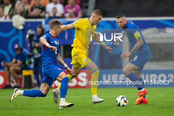 Artem Dovbyk (C) of Ukraine is missing a chance to score against Peter Pekarik (L) and Milan Skriniar (R) of Slovakia  during the UEFA EURO...