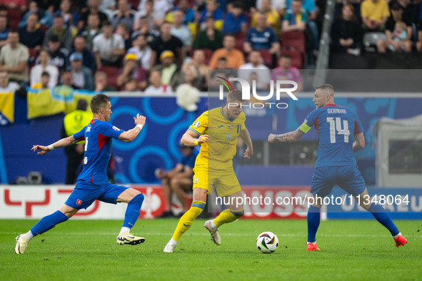 Artem Dovbyk (C) of Ukraine is missing a chance to score against Peter Pekarik (L) and Milan Skriniar (R) of Slovakia  during the UEFA EURO...