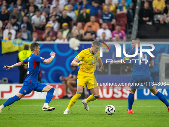 Artem Dovbyk (C) of Ukraine is missing a chance to score against Peter Pekarik (L) and Milan Skriniar (R) of Slovakia  during the UEFA EURO...