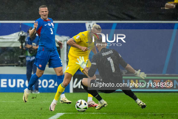 Mykhailo Mudryk of Ukraine is playing against Martin Dubravka of Slovakia (L-R)  during the UEFA EURO 2024 group stage match between Slovaki...