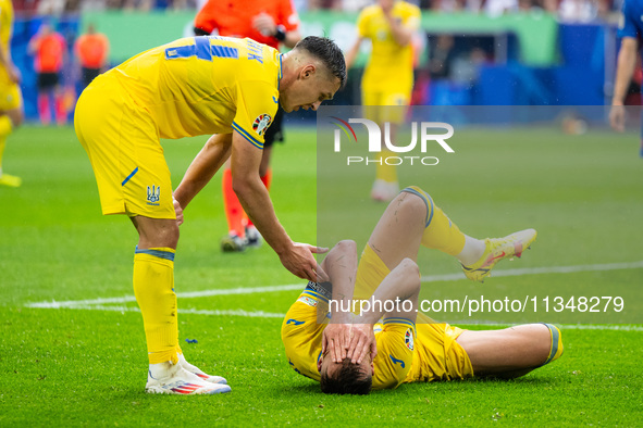 Oleksandr Tymchyk and Andriy Yarmolenko of Ukraine are standing (L-R)  during the UEFA EURO 2024 group stage match between Slovakia and Ukra...