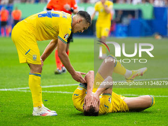 Oleksandr Tymchyk and Andriy Yarmolenko of Ukraine are standing (L-R)  during the UEFA EURO 2024 group stage match between Slovakia and Ukra...