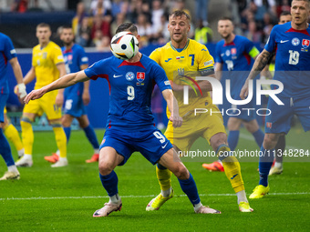 Robert Bozenik of Slovakia is battling for possession with Andriy Yarmolenko of Ukraine (L-R)  during the UEFA EURO 2024 group stage match b...