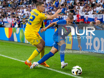 Mykola Matvienko of Ukraine is battling for possession with Lukas Haraslin of Slovakia (L-R)  during the UEFA EURO 2024 group stage match be...