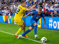 Mykola Matvienko of Ukraine is battling for possession with Lukas Haraslin of Slovakia (L-R)  during the UEFA EURO 2024 group stage match be...