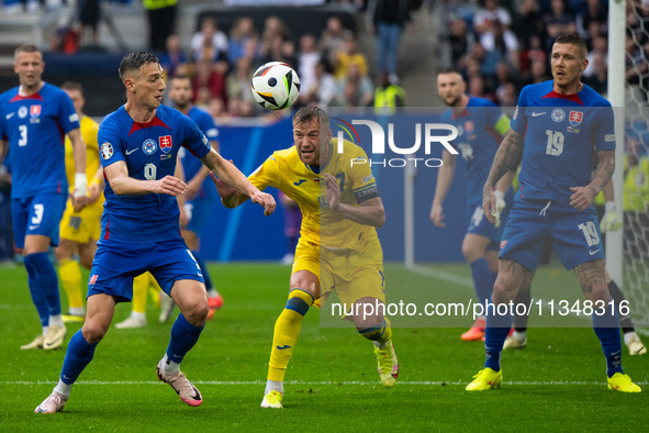 Robert Bozenik of Slovakia is battling for possession with Ruslan Malinovskyi of Ukraine  during the UEFA EURO 2024 group stage match betwee...