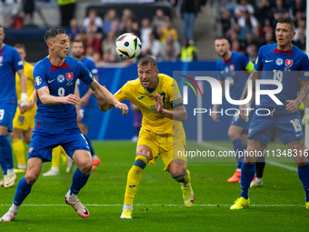 Robert Bozenik of Slovakia is battling for possession with Ruslan Malinovskyi of Ukraine  during the UEFA EURO 2024 group stage match betwee...