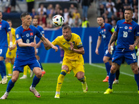 Robert Bozenik of Slovakia is battling for possession with Ruslan Malinovskyi of Ukraine  during the UEFA EURO 2024 group stage match betwee...