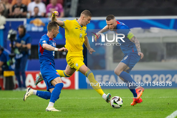 Artem Dovbyk (C) of Ukraine is missing a chance to score against Peter Pekarik (L) and Milan Skriniar (R) of Slovakia  during the UEFA EURO...