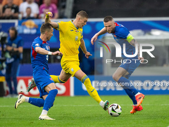 Artem Dovbyk (C) of Ukraine is missing a chance to score against Peter Pekarik (L) and Milan Skriniar (R) of Slovakia  during the UEFA EURO...